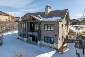 Snow covered house with a balcony and cooling unit