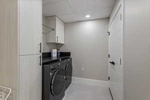 Clothes washing area with separate washer and dryer and cabinets