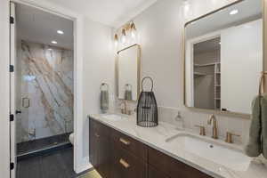 Bathroom featuring tile patterned floors, vanity, toilet, and a shower with door