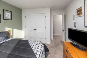 Carpeted bedroom featuring a closet