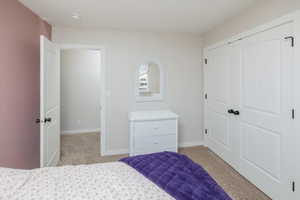 Carpeted bedroom with a closet