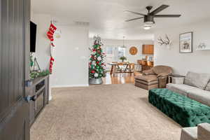 Living room featuring carpet floors and ceiling fan