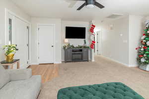 Living room featuring light carpet and ceiling fan