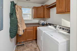 Clothes washing area with cabinets and separate washer and dryer