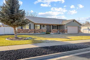 Ranch-style house featuring covered porch, a garage, and a front lawn