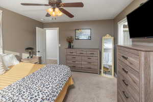 Carpeted bedroom with a textured ceiling and ceiling fan