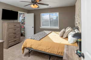 Bedroom with light colored carpet and ceiling fan