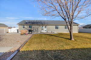 Rear view of house with a yard and a patio