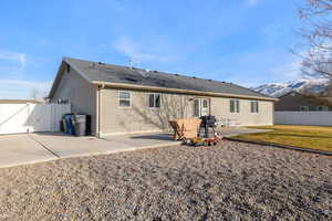 Back of property with a patio area, a mountain view, and a yard