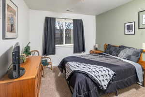 Carpeted bedroom with a textured ceiling