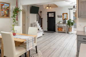 Dining area featuring beam ceiling, light hardwood / wood-style floors, and a notable chandelier