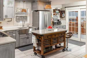 Kitchen featuring a healthy amount of sunlight, sink, stainless steel appliances, and hanging light fixtures