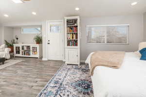 Bedroom featuring multiple windows and wood-type flooring