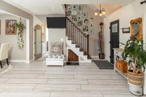 Foyer featuring light wood-type flooring and an inviting chandelier