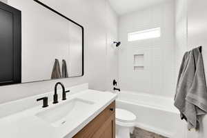 Full hall/guest bathroom with vanity, toilet, and tiled shower/bath