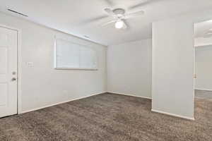 Carpeted spare room featuring ceiling fan