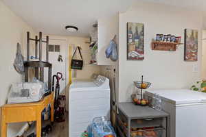 Clothes washing area featuring hardwood / wood-style floors and washing machine and dryer