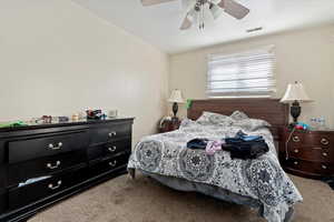 Carpeted bedroom with ceiling fan and lofted ceiling