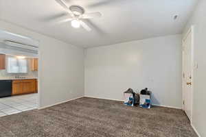 Carpeted empty room featuring ceiling fan and sink