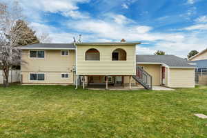 Back of property with a yard, cooling unit, and a patio