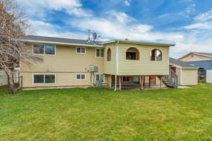 Rear view of property featuring a lawn, cooling unit, and a patio