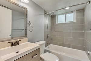 Full bathroom with vanity, toilet, and tiled shower / bath