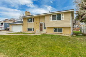 Bi-level home with a front yard and a garage