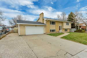 Bi-level home with a garage and a front lawn