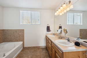 Bathroom with tile patterned flooring, vanity, a healthy amount of sunlight, and a bath