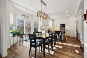 Dining space featuring a notable chandelier, dark hardwood / wood-style floors, and sink