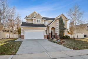 View of front of property featuring a garage and a front lawn