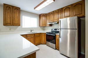 Kitchen featuring appliances with stainless steel finishes, light hardwood / wood-style flooring, and sink