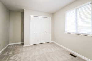 Unfurnished bedroom with a closet and light colored carpet