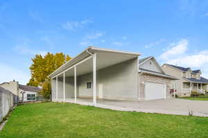 Rear view of property with a yard and a carport