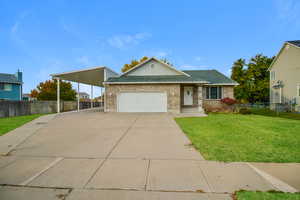 View of front of property featuring a garage, a front yard, and a carport