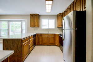 Kitchen featuring kitchen peninsula, sink, stainless steel appliances, and light wood-type flooring