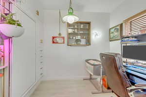 Home office with light hardwood / wood-style flooring