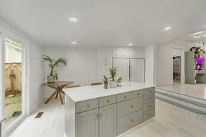 Kitchen featuring paneled fridge, plenty of natural light, a kitchen island, and light hardwood / wood-style flooring