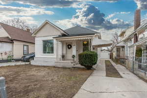 View of front of home featuring a garage and an outbuilding