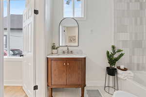 Bathroom featuring a bathing tub, vanity, and hardwood / wood-style flooring