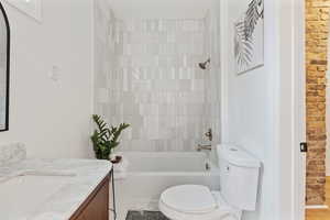 Full bathroom featuring vanity, toilet, and tiled shower / bath combo