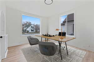 Office space with light hardwood / wood-style floors