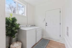 Laundry area featuring washer and clothes dryer and light hardwood / wood-style flooring