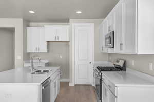 Kitchen featuring sink, light hardwood / wood-style floors, white cabinets, and appliances with stainless steel finishes