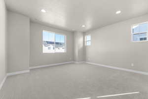 Spare room with light carpet and a textured ceiling