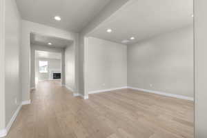 Empty room with a textured ceiling and light wood-type flooring