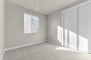 Unfurnished room featuring light carpet