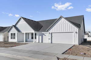 Modern inspired farmhouse featuring a garage and central air condition unit