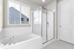 Bathroom featuring tile patterned floors and plus walk in shower