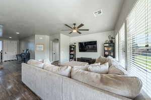 Living room with recessed lighting, dark wood-style floors, visible vents, arched walkways, and ceiling fan